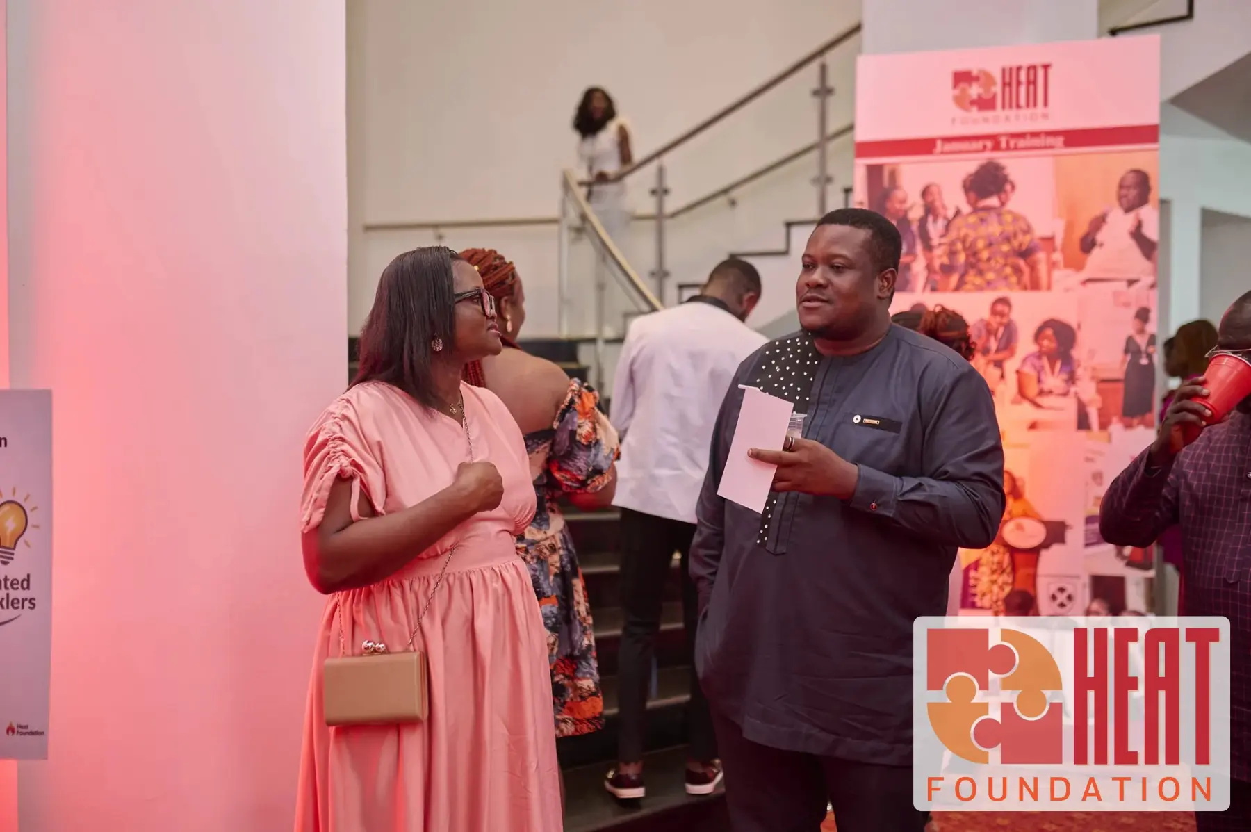 Guests conversing near a teacher journey display at the graduation event